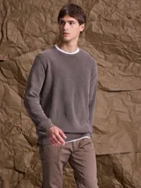 Sweater de punto en color azul marino, con cuello redondo y mangas raglán. Presenta un tejido acanalado fino y puños elásticos.