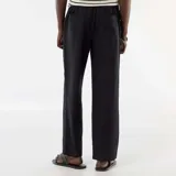 Pantalón de lino mezclado de corte recto y color negro, con bolsillos laterales y cintura elastizada.