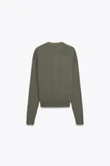 Cardigan de punto en tejido 100% cashmere, color verde oliva, con cuello redondo, manga larga y cierre frontal con botones. Presenta terminaciones en rib en puños y ruedo.