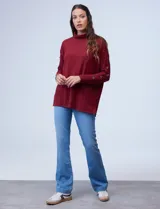 Polera negra de tejido soft con cuello alto y mangas largas con aplique de botones.