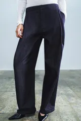 Jeans de tiro alto de la colección ZW de Zara, en color azul oscuro, con bolsillos delanteros, raya planchada en el delantero y cierre con cremallera y gancho metálico.
