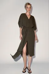 Vestido midi ZW Collection de color verde militar, con escote en pico, mangas anchas por debajo del codo y cierre frontal con alamares. Cuenta con un cinturón del mismo tejido para anudar en la cintura y bajo acabado en línea evasé.