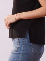 Buzo de tejido acanalado marca Tahari, con cuello redondo a la base y mangas tipo dolman. Presenta un diseño de líneas verticales y diagonales en el tejido.