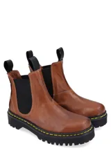 Bota Chelsea de cuero negro con elásticos laterales, suela track y tiradores en la caña.