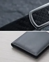 Pulsera masculina con banda de goma negra con textura de fibra de carbono y placa central de acero inoxidable.