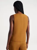 Chaleco sastrero de lino color marrón, con escote en V, cierre frontal con botones y bolsillos laterales simulados.