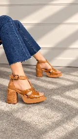 Sandalias de taco alto ancho con plataforma, color tostado, con tiras delanteras entrelazadas en cuero grabado tipo cocodrilo y capellada lisa, tiras laterales y correa al tobillo con hebilla metálica ajustable.