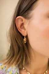 Aros colgantes de acero quirúrgico con baño en oro, con diseño de nudo texturizado.