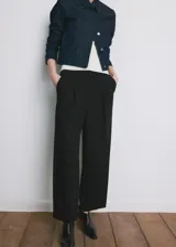 Pantalón de vestir negro de tiro medio y corte recto, con detalle de pinzas y bolsillos laterales.
