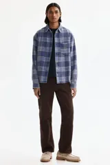 Camisa de sarga de algodón con diseño a cuadros, cuello inglés, bolsillo superior y mangas largas con puños abotonados.