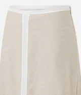 Pollera evasê midi color beige, confeccionada en viscolino, con cintura de sastrería, bieses contrastantes y cierre lateral por cremallera.