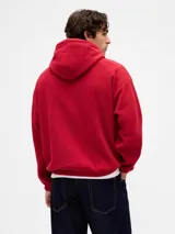 Canguro de polar rojo con capucha y cordones ajustables. Presenta el logo de la marca estampado en blanco en el centro del pecho y un bolsillo frontal tipo canguro.