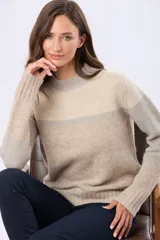 Buzo tejido con diseño de bloques de color en tonos beige, gris claro y gris oscuro. Posee un cuello redondo y corte holgado.