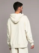 Buzo con capucha Calvin Klein de felpa de algodón color beige, de corte relajado, con bolsillo tipo canguro y logo bordado en el pecho.