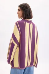 Sweater de punto con diseño de rayas verticales en tonos violeta y amarillo, de cuello redondo y mangas largas.