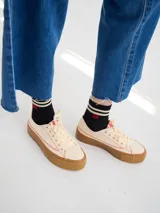 Championes de lona negra con plataforma y puntera de goma marrón, cordones negros y costuras en contraste.