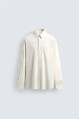 Camisa de corte relajado confeccionada en tejido con mezcla de lino. Presenta cuello solapa, manga larga con puños abotonados, bolsillo plastrón en el pecho y cierre frontal con botones. Incluye bordados a contraste en la espalda.