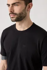 Remera de algodón de corte clásico, color negro, con cuello redondo y logo pequeño bordado en el pecho.