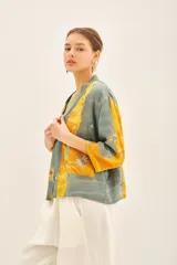 Kimono corto de viscosa con diseño estampado en tonos amarillo y gris, decorado con bordados en hilo de lurex. Presenta un corte holgado con mangas tres cuartos y un cinturón integrado de la misma tela.