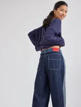 Pantalon ancho de denim en varios tonos de azul con diseño patchwork, de tiro medio y cierre frontal con botones.