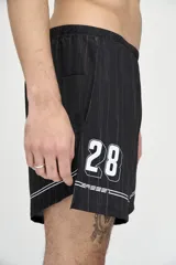 Short de fútbol negro con finas rayas verticales blancas, cintura elástica y cordón ajustable. Presenta logo "Basset" y escudo de equipo de fútbol con el número 28.