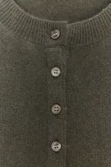 Cardigan de punto en tejido 100% cashmere, color verde oliva, con cuello redondo, manga larga y cierre frontal con botones. Presenta terminaciones en rib en puños y ruedo.