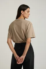 Remera de algodón de manga corta y cuello redondo, con diseño holgado y estampado gráfico frontal con motivos florales y tipografía vintage.