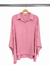Camisa de corte relajado y diseño holgado, con cuello clásico, cierre frontal de botones y mangas largas con caída fluida.