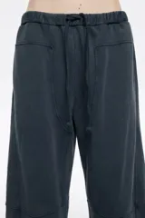 Pantalón jogger de corte barrel confeccionado en algodón color azul oscuro. Presenta tiro bajo, cintura ajustable con cordones, bolsillos laterales en costura y bolsillos traseros de plastrón. Incluye detalles de cortes en las rodillas para mayor estructura.
