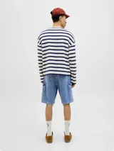 Bermuda cargo de jean baggy fit con tiro alto, múltiples bolsillos y pernera amplia. Presenta un acabado stonewash con efecto desgastado.
