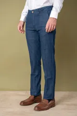 Pantalón de vestir azul denim, corte slim fit, con bolsillos laterales y traseros.