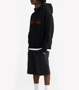 Hoodie color beige con capucha, cordones ajustables y bolsillo tipo canguro. Estampa bordada en el frente con la leyenda "Poona Studio".