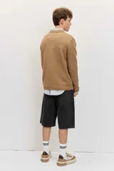 Sweater gris oscuro de punto con cuello redondo, manga larga y puños y dobladillo acanalados.
