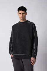 Buzo de frisa 100% algodón, color negro con lavado gastado tipo "snow". Presenta un calce oversize, cuello redondo, puños y cintura de ribb. Se caracteriza por sus costuras a contratono visibles en toda la prenda y recortes con bordado.