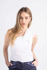 Musculosa blanca de lino con un solo hombro y volados en el hombro. Tiene elástico en la espalda para adaptarse a varios talles.