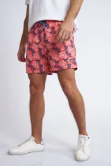 Short de baño con cintura elástica y cordón ajustable, confeccionado en tela ligera de secado rápido. Presenta un estampado botánico integral en tonos amarillos, blancos y azules, con dos bolsillos delanteros y uno posterior.