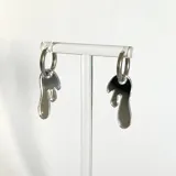 Par de aros colgantes plateados con forma de gota.