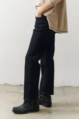 Pantalón marrón de corte recto con cinturón de cuero marrón con hebilla metálica.