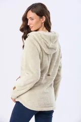 Campera de tejido sherpa color beige con capucha, cierre frontal y detalles en cuero sintético. Presenta una textura suave y abrigada, ideal para la temporada de invierno.