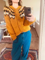 Cárdigan mostaza tejido a mano con botones al frente.