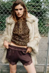 Jersey de punto con textura suave, cuello redondo y manga larga. Presenta un estampado animal print en tonos marrones y cierre frontal con botones.