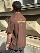 Remera marrón de corte oversize con estampado pequeño en el pecho.