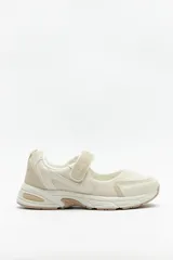 Zapatillas deportivas color beige, con suela confortable de 4cm de alto y tira ajustable con velcro.