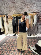 Musculosa negra con bordado floral, escote en V y breteles finos.