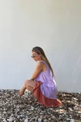 Vestido corto lila con panel frontal en color lavanda y ruedo color ladrillo.