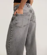 Pantalón skater de jean color gris con lavado dirty, tiro bajo, trabillas anchas en la cintura y bolsillos diferenciados.