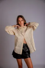 Camisa color crema con bordado de flores blancas, de manga larga abullonada y cuello clásico.