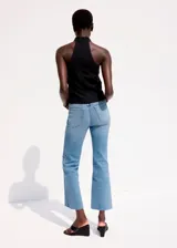 Jeans de denim celestes de corte recto, con tiro medio, bolsillos clásicos y terminación deshilachada en los tobillos.