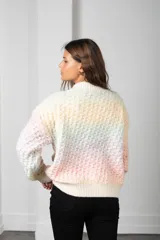 Cárdigan de tejido grueso con diseño de textura en relieve, corte oversize y cierre frontal con botones. Presenta un patrón de colores pastel en bloques.