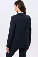 Blazer azul marino de corte entallado, confeccionado en algodón con elastano, con solapas clásicas y bolsillos frontales con solapa.